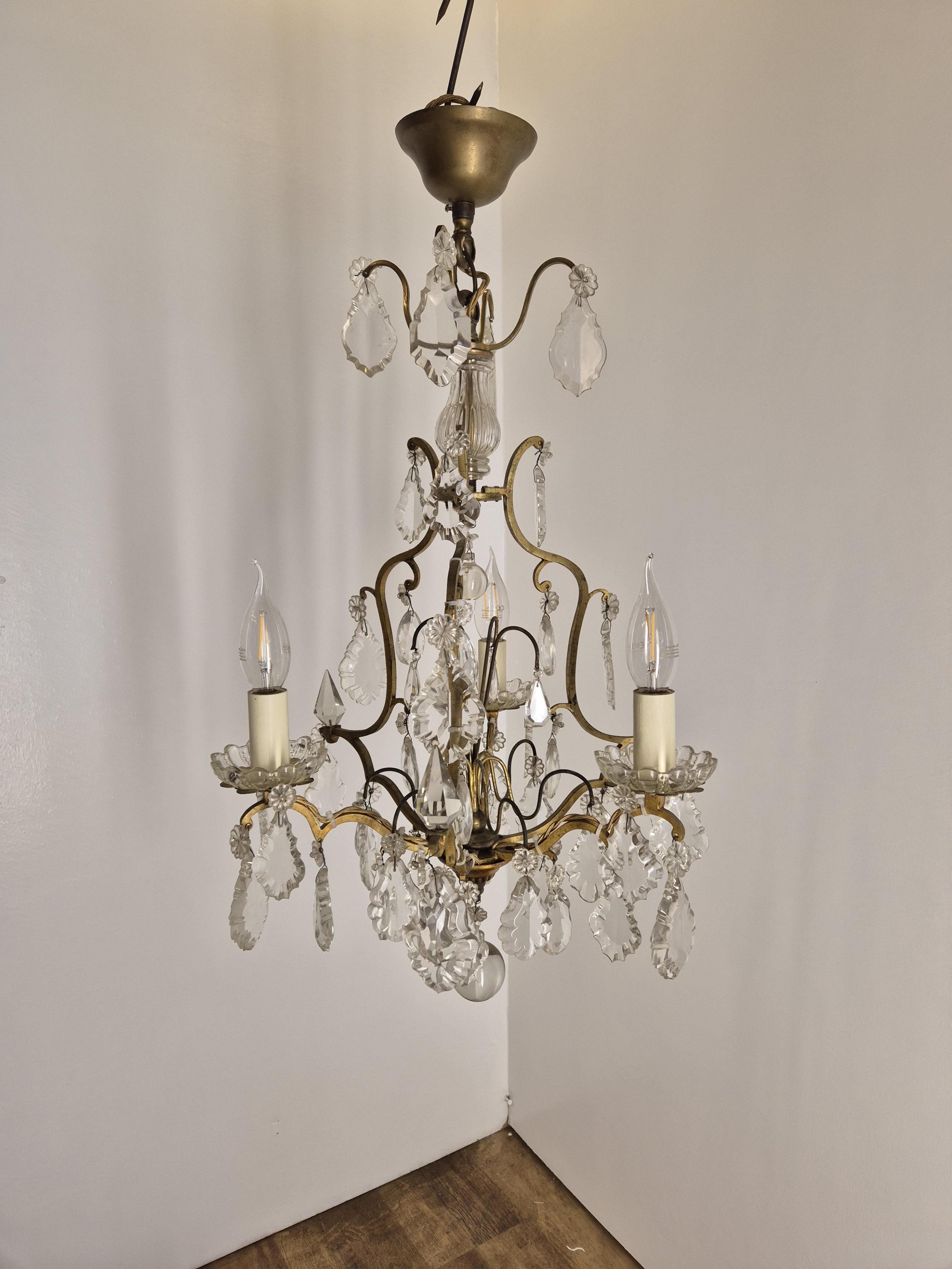 A French gilded three light chandelier with crystal drops, circa 1930's, wired, overall 68cm high, 39cm wide. Condition- fair to good, not tested